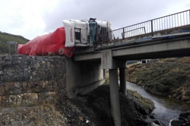 Un camión volcó y quedó al borde de caer de un puente